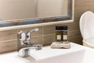 a bathroom with a sink with a mirror and a toothbrush at Kanelis on the hill in Mytakas