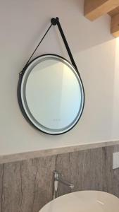 a mirror hanging on a wall above a sink at Casa bragosso in Sottomarina