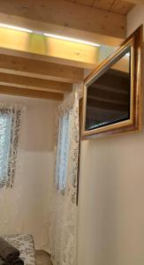 ein Schlafzimmer mit einem Fenster und einem Spiegel an der Wand in der Unterkunft Casa bragosso in Sottomarina