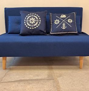 a blue couch with pillows on top of it at Casa bragosso in Sottomarina