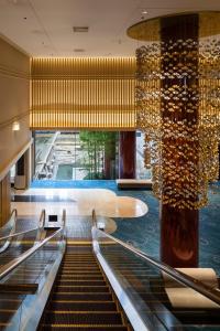 a hotel lobby with a swimming pool and stairs at Kyoto Tokyu Hotel in Kyoto