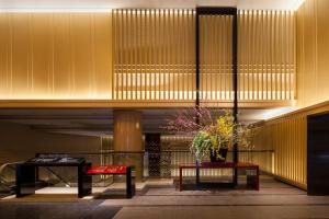 a lobby with two tables and a vase of flowers at Kyoto Tokyu Hotel in Kyoto