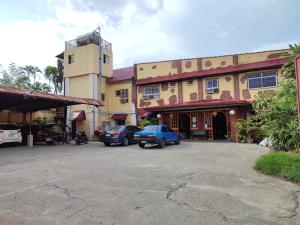 un aparcamiento frente a un edificio con coches aparcados en El Juliana Hotel, en Vigan