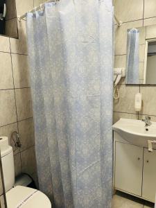 łazienka z zasłoną prysznicową i umywalką w obiekcie Casa Elena w Konstancy