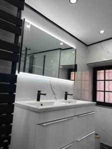 ein weißes Badezimmer mit einem Waschbecken und einem Spiegel in der Unterkunft Love room La Parenthèse Carnoules in Carnoules