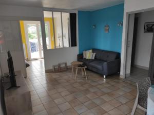 ein Wohnzimmer mit einem Sofa und einem Tisch in der Unterkunft Maison de vacances La Quercynoise in Flaujac-Poujols