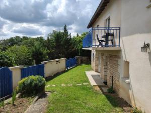 um quintal ao lado de uma casa com uma cerca azul em Maison de vacances La Quercynoise em Flaujac-Poujols