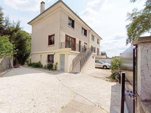 a large white house with a gate in front of it at T2 COSY * PARKING * WIFI * PARIS-DISNEY in Villiers-sur-Marne