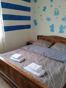 een slaapkamer met een bed met twee handdoeken erop bij NaBaDa in Tsʼageri