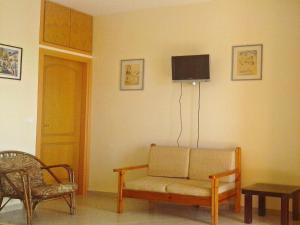 a living room with a couch and a tv on the wall at Seaview Studio in beautiful setting west from Chania in Ravdhoúkha