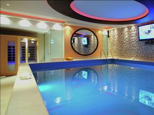 a large swimming pool in a room with a tv at Scenic Villa in Paleokastrites with Sauna in Gouvia