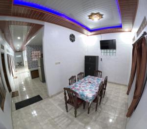 ein Esszimmer mit einem Tisch und Stühlen in der Unterkunft Griyo Mondoliko Homestay Jogja in Demangan