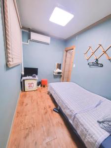 首爾的住宿－韓國納魯旅舍，蓝色客房中一间带床的卧室