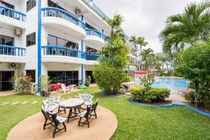 a patio with a table and chairs in front of a building at Kamala - The Club Residence -2 BR Pool View Residence in Kamala Beach