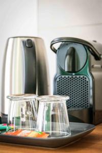 a counter with a toaster and two glass votives at L'Albatros 001 - Hypercentre * Cosy * Wifi in Saint-Quentin