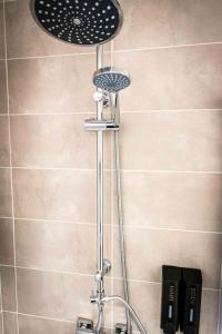 a shower with a shower head in a bathroom at L'Albatros 001 - Hypercentre * Cosy * Wifi in Saint-Quentin