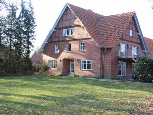 ein großes rotes Backsteinhaus mit großem Hof in der Unterkunft Landhaus Eichengarten in Soltau