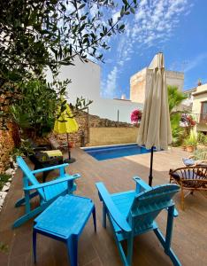 a group of blue chairs and an umbrella and a pool at Boutique Hostal Lorca in Nerja