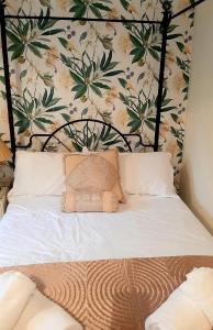 - une chambre avec un lit orné d'un mur fleuri dans l'établissement Beaford Country House, à Winkleigh
