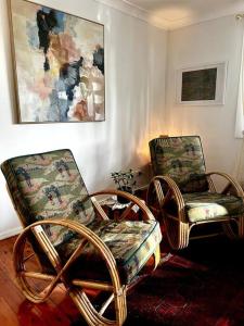 ein Zimmer mit zwei Stühlen und einem Gemälde an der Wand in der Unterkunft The Treehouse at Copa in Copacabana