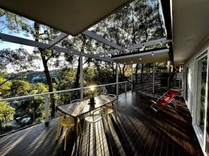 a deck with a table and a chair on a balcony at The Treehouse at Copa in Copacabana