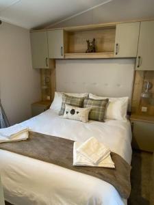 een slaapkamer met een groot wit bed met kussens bij Perfect for country lovers in Grantown on Spey