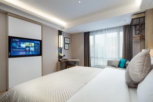 a bedroom with a white bed and a tv at 莫林酒店(Moning Hotel） in Sihanoukville