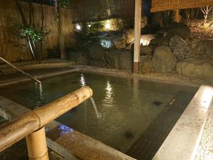 a pool of water with a wooden pole in it at Kasuga Hotel in Nara