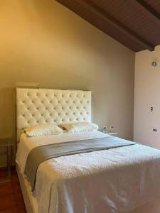 um quarto com uma cama grande e uma cabeceira branca em Casa dentro del Campo de Golf em Comayagua