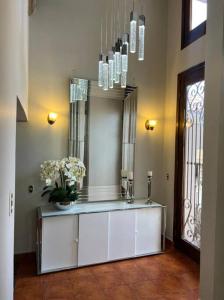 a room with a mirror and a counter with flowers on it at Casa dentro del Campo de Golf in Comayagua