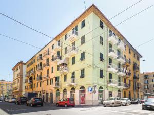 a yellow building with cars parked in front of it at La Malva - L'Opera Group in La Spezia