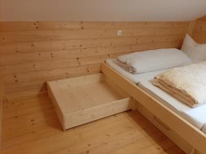 a small room with a bed in a wooden wall at Ferienhütte Heinle in Oberstaufen
