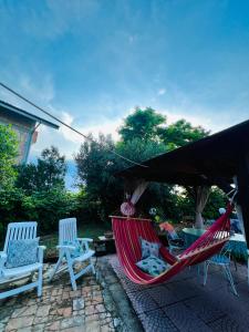 a hammock and two chairs on a patio at B&B LA BOUGANVILLE in Spoltore