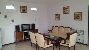 un soggiorno con tavolo, sedie e TV di In Villa Garden Resort a Batu