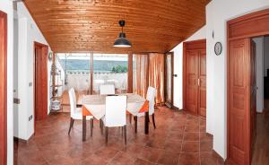 a dining room with a table and white chairs at Rooms Agroturizam Romano in Buje