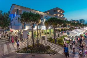 uma multidão de pessoas andando em frente a um edifício em Hotel Giove em Cesenatico