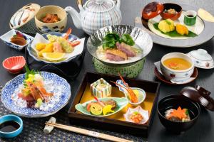 a table topped with plates of food and bowls of soup at Kasuga Hotel in Nara