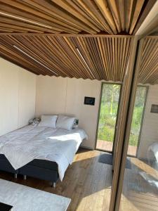 ein Schlafzimmer mit einem Bett in einem Zimmer mit Glasschiebetüren in der Unterkunft Looduskeskne Olivia moodulmaja Põltsamaal 