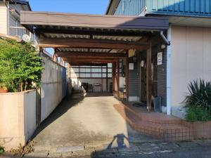 einen Eingang zu einem Gebäude mit einer hölzernen Markise in der Unterkunft 快適に滞在&家族利用等におすすめ 洋室と和室が繋がったお部屋 in Gifu