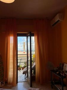 a room with orange curtains and a door with a view at Scalea City Center Apartments in Scalea