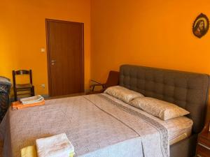 a bedroom with a large bed with an orange wall at Scalea City Center Apartments in Scalea