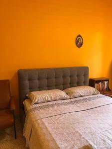 a bedroom with a bed with an orange wall at Scalea City Center Apartments in Scalea