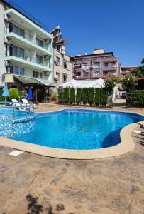 a large swimming pool in front of a building at Mirana Family Hotel in Burgas City