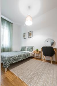 a bedroom with a bed and a chair in it at VERTIGO One Bedroom apartment - Free private parking-Fast WI-FI in Novi Sad