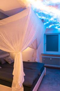ein Schlafzimmer mit einem Bett mit Moskitonetz in der Unterkunft Love Cottage 2 mit Whirlpool in Hagen