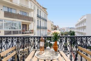 Un balcón con una mesa con flores. en Studio proche Croisette et centre, en Cannes