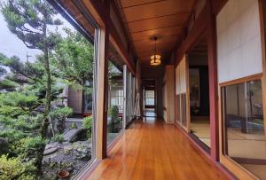 un pasillo de una casa con grandes ventanas de cristal en 大湖人家　田園風景を眺めなれる、ゆったりとしたゴージャスな屋敷 en Taga