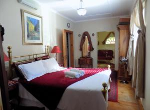 1 dormitorio con 1 cama grande con manta roja en Jaloersplek / Victorian On Vaal, en Parys