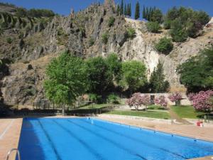 a large swimming pool in front of a mountain at APARTAMENTO EL PEÑON in La Iruela