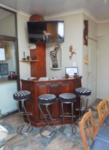 una cocina con una barra con 4 taburetes en Jaloersplek / Victorian On Vaal, en Parys